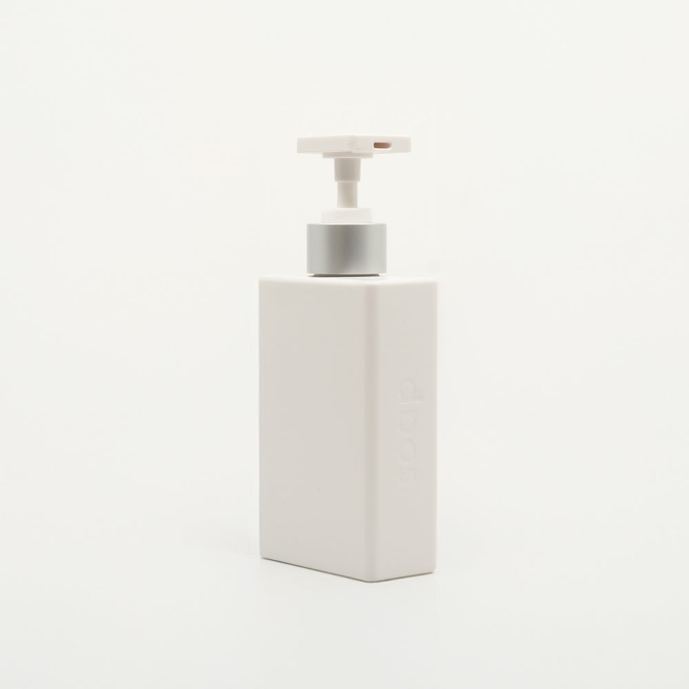 A white, rectangular soap dispenser with a pump, against a white background.