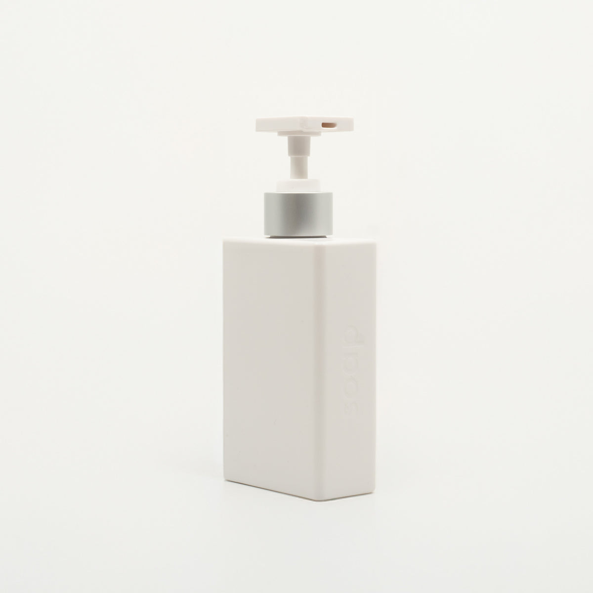 A white, rectangular soap dispenser with a pump, against a white background.