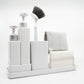 White cleaning caddy with various cleaning tools on a white background