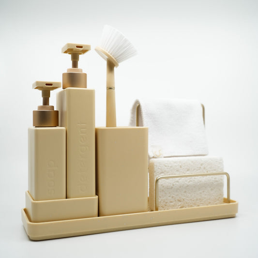 Beige bathroom accessory set with bottles, a brush, and towels on a white background